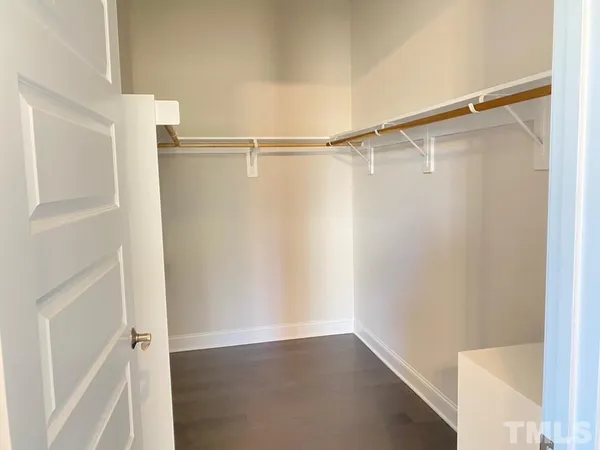 a view of walk in closet with empty racks