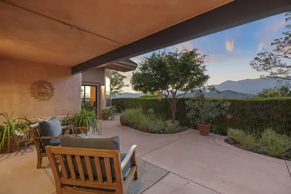 a view of a patio with couches table and chairs and potted plants