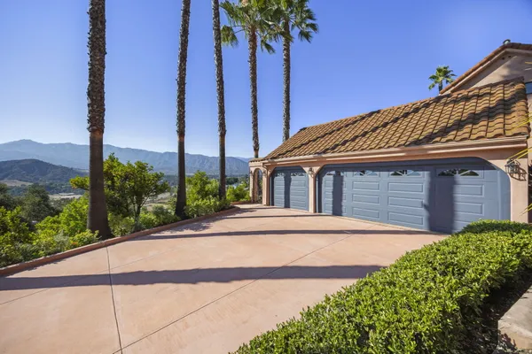 a front view of a house with a yard and potted plants