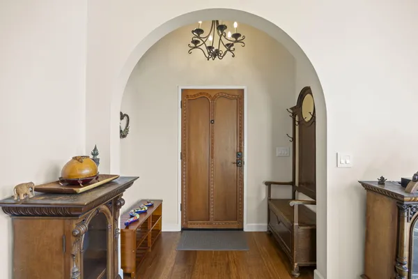 a kitchen with stainless steel appliances granite countertop a stove top oven a refrigerator a dining table and chairs with wooden floor