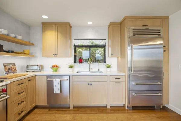 a kitchen with stainless steel appliances granite countertop a sink stove and refrigerator