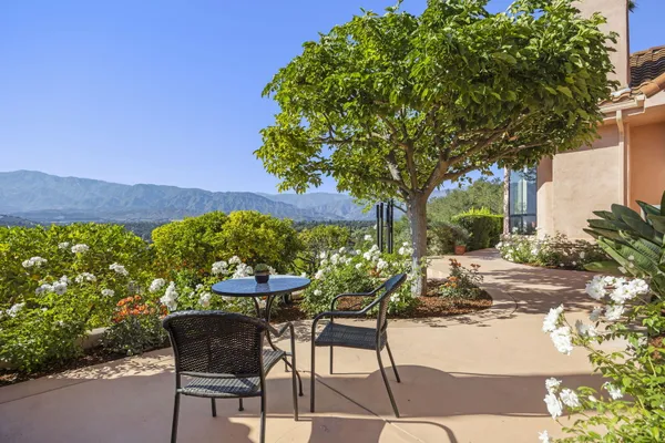 a view of a porch with chairs and potted plants