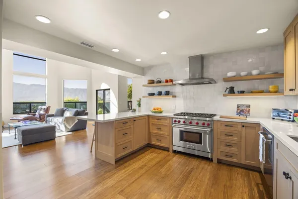 a kitchen with stainless steel appliances granite countertop wooden floors and view living room