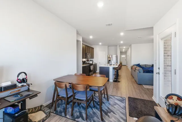 a kitchen with a stove a sink a dining table and chairs