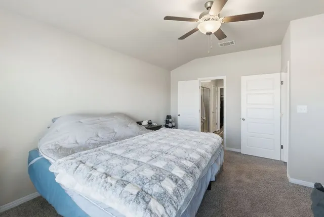 a bedroom with a bed a study table and large window