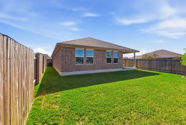 a view of a garden with a house in the background