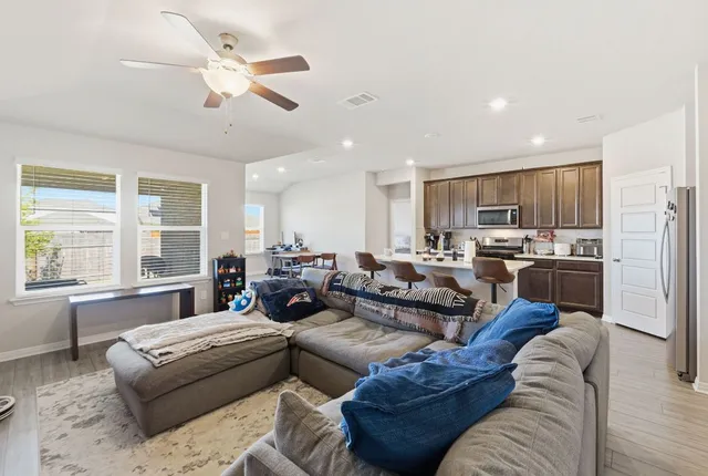 a living room with furniture kitchen and a large window