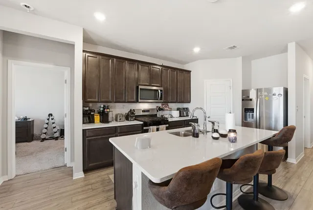 a kitchen with sink refrigerator and microwave
