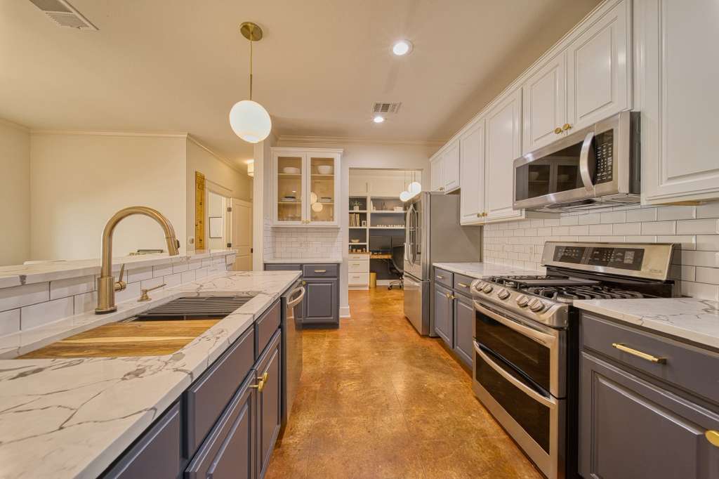 4113 Camacho Street Austin, TX 78723 - Photo 13 of 36 a kitchen with stainless steel appliances granite countertop a stove a sink and a microwave