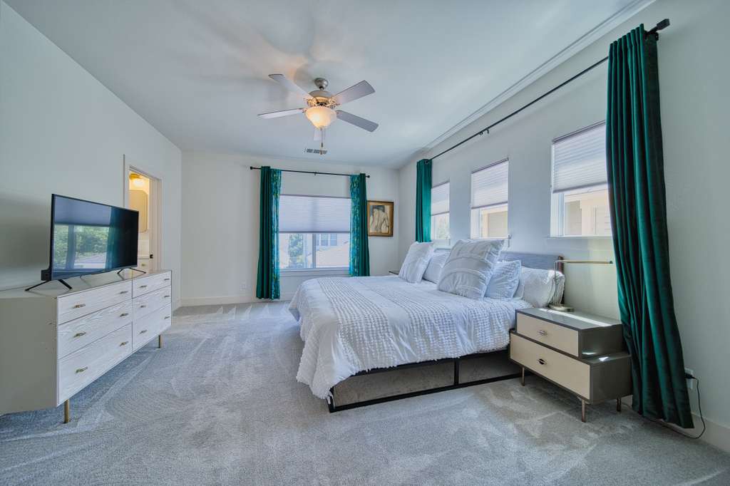 4113 Camacho Street Austin, TX 78723 - Photo 19 of 36 a spacious bedroom with a bed and a flat screen tv