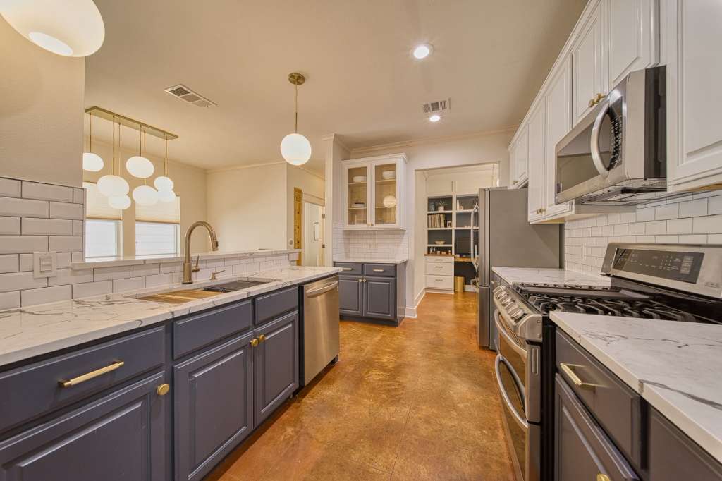 4113 Camacho Street Austin, TX 78723 - Photo 10 of 36 a large kitchen with stainless steel appliances granite countertop a stove and a sink