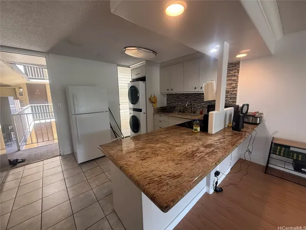 a kitchen with kitchen island granite countertop a stove refrigerator and microwave