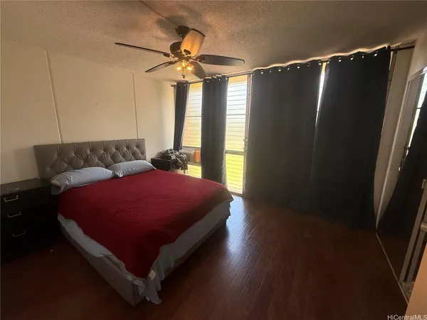a bed sitting in a bedroom next to a window and a chandelier