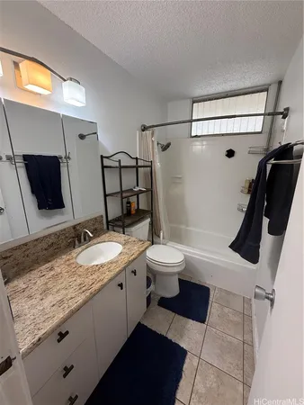 a bathroom with a granite countertop sink mirror vanity and toilet