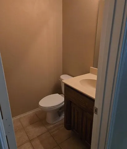 an empty room with wooden floor kitchen view and windows