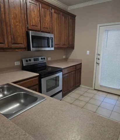a kitchen with stainless steel appliances granite countertop a stove microwave and sink
