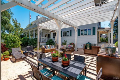a view of a house with backyard and sitting area