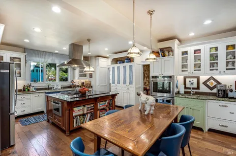 a kitchen with stainless steel appliances a stove a sink dishwasher and cabinets with wooden floor
