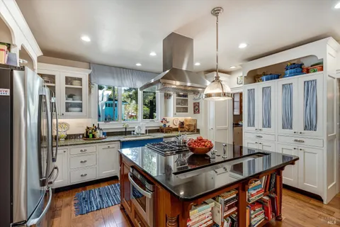 a kitchen with stainless steel appliances granite countertop a stove refrigerator and cabinets