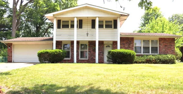 a view of a house with large windows and plants