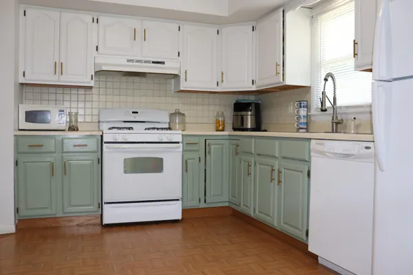 a kitchen with cabinets appliances a sink and a window