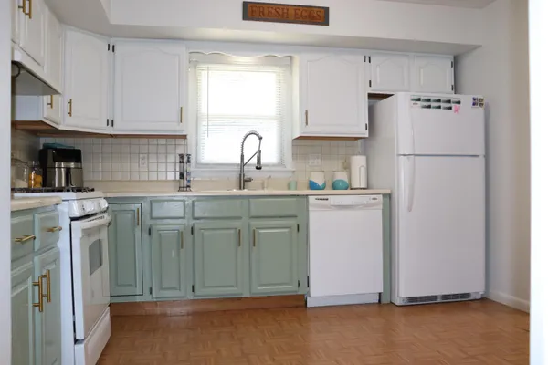 a kitchen with a sink a refrigerator and cabinets