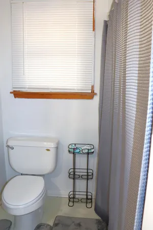 a white toilet sitting next to a window