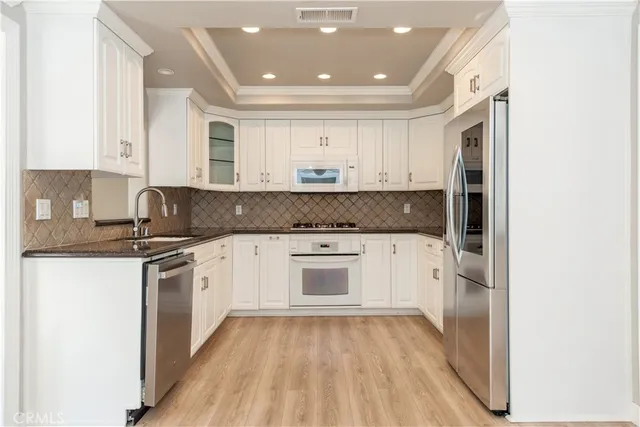 a kitchen with granite countertop white cabinets and white appliances