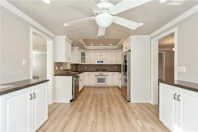 a large kitchen with cabinets wooden floor and stainless steel appliances