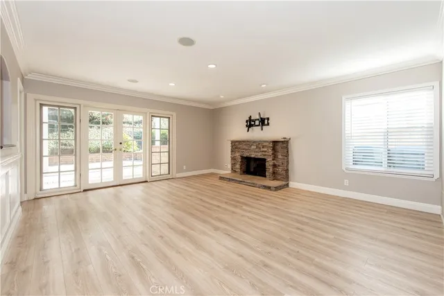 a view of empty room with wooden floor and fireplace