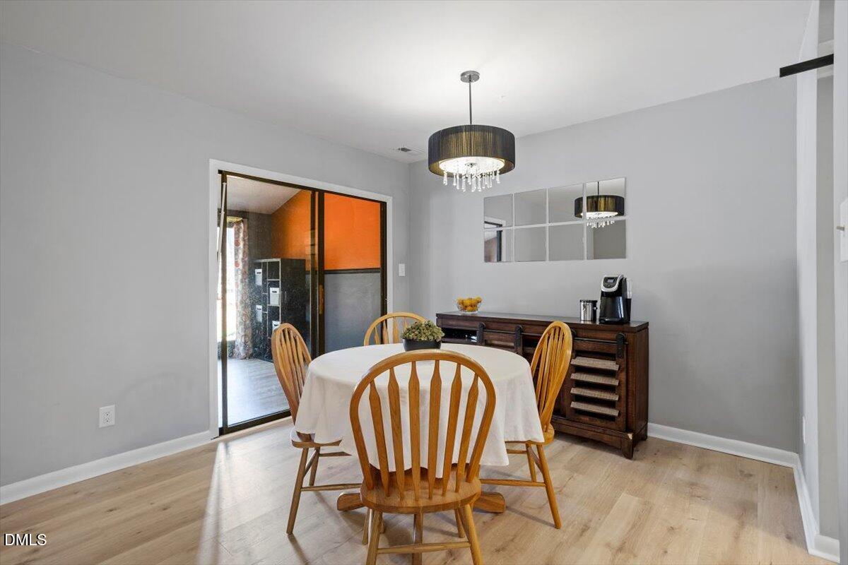 712 Godwin Court Raleigh, NC 27606 - Photo 15 of 27 a view of a dining room with furniture wooden floor and chandelier