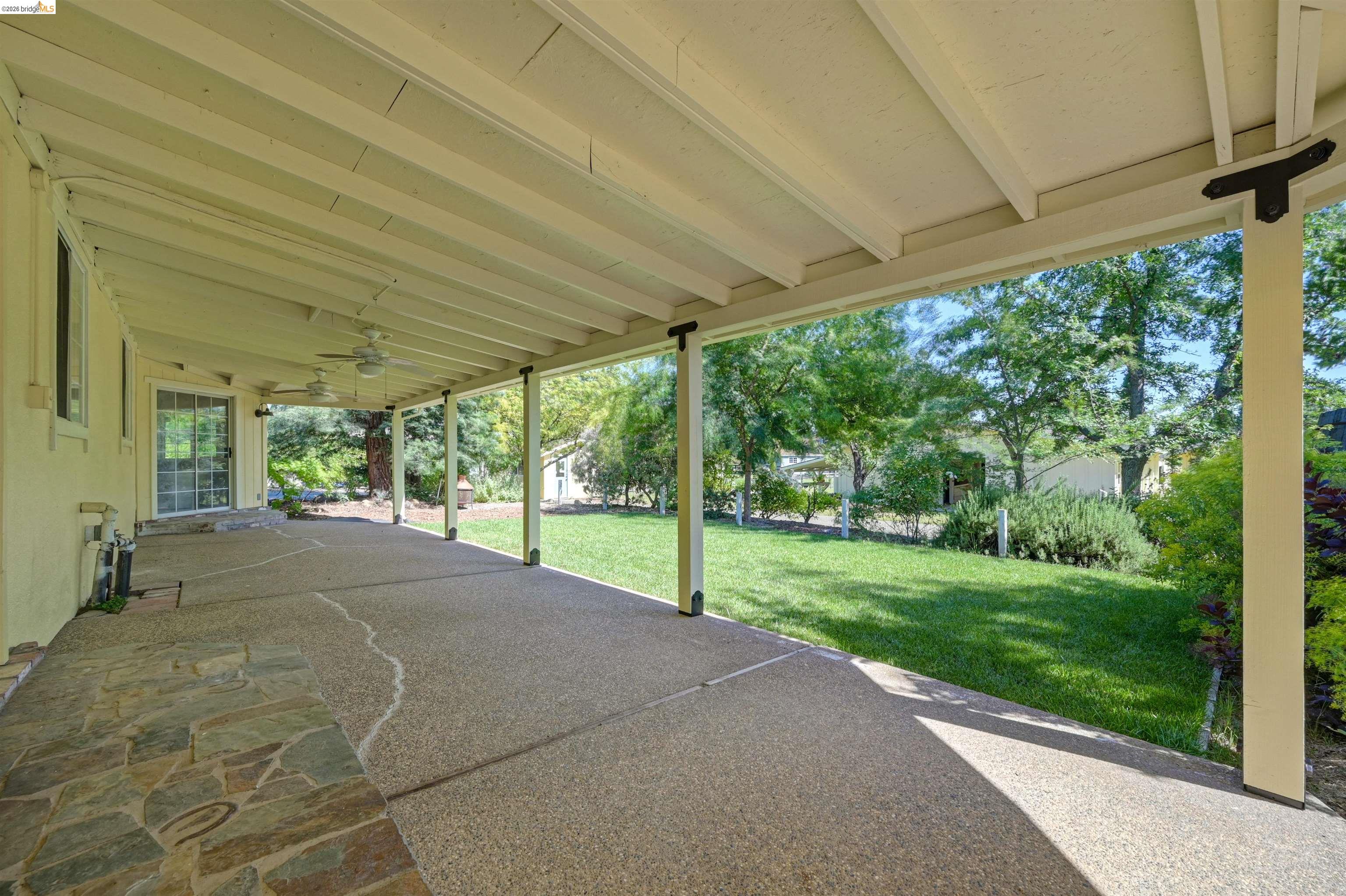 10474 Sheldon Road Elk Grove, CA 95624 - Photo 50 of 83 Expansive covered patio featuring an exposed aggregate concrete surface, irregular flagstone accents, and multiple ceiling fans