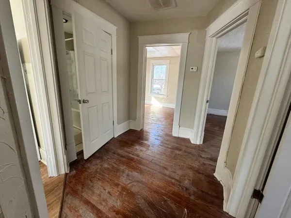 a view of a hallway with wooden floor
