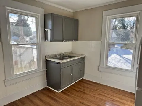 a kitchen with a wooden floor and a window