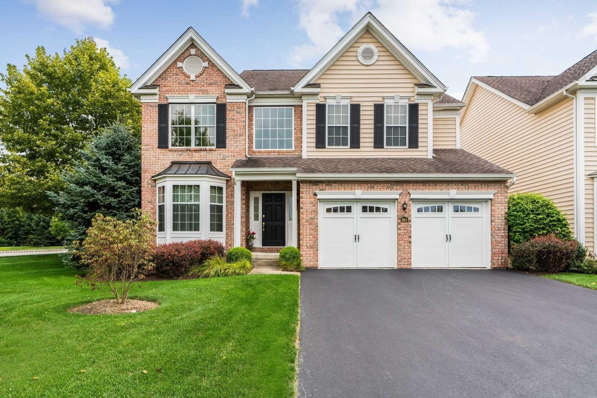 a front view of a house with a yard and trees