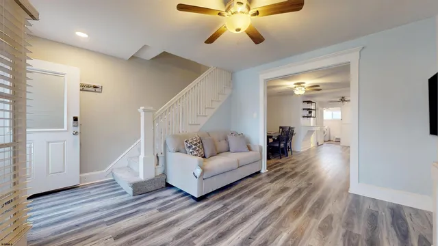 a living room with furniture and a wooden floor