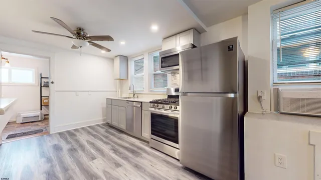 a kitchen with stainless steel appliances granite countertop a refrigerator a stove a sink and a refrigerator