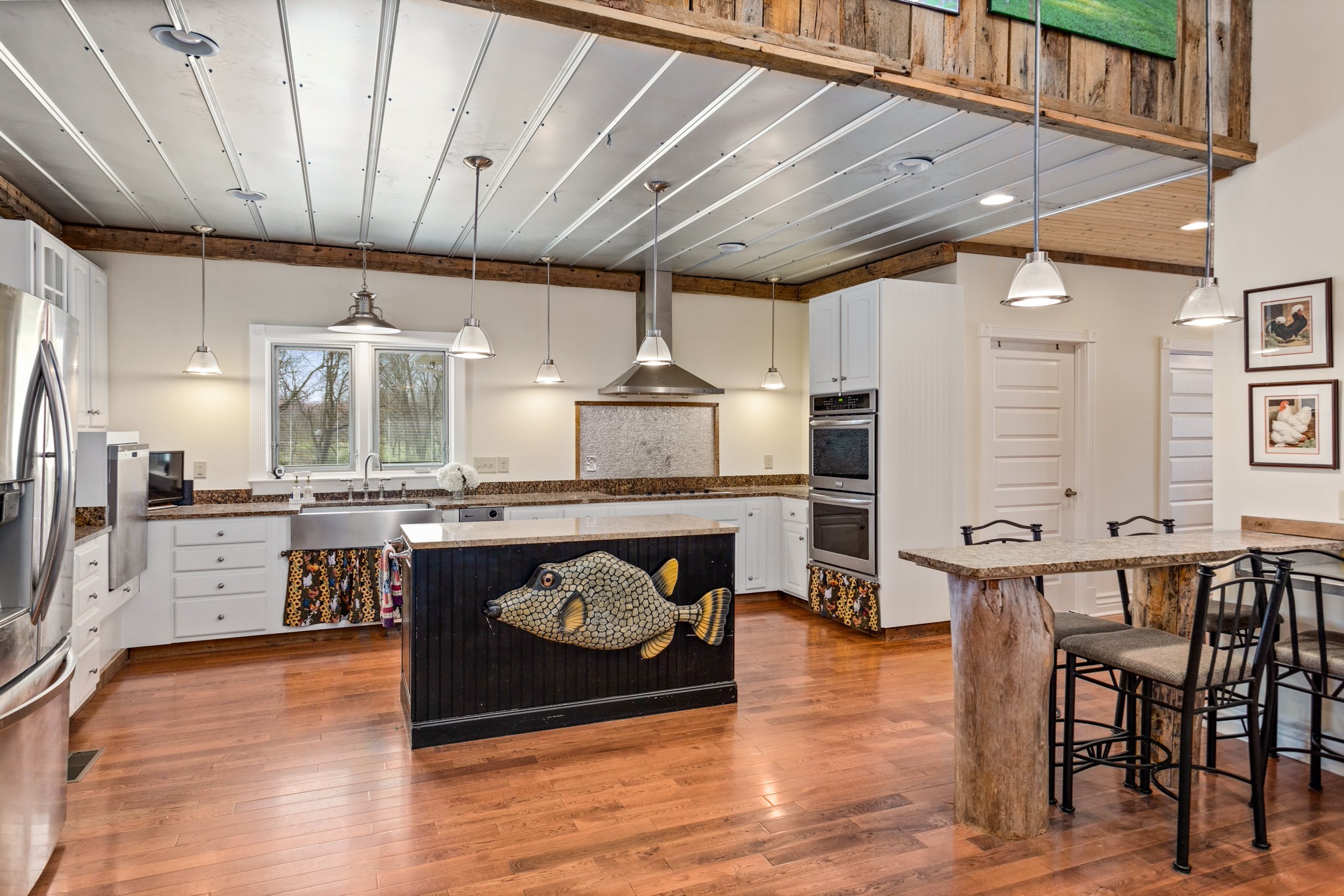 2833 Thompson's Station Road East Thompson's Station, TN 37179 - Photo 11 of 38 a kitchen with stainless steel appliances granite countertop a table chairs and wooden floors