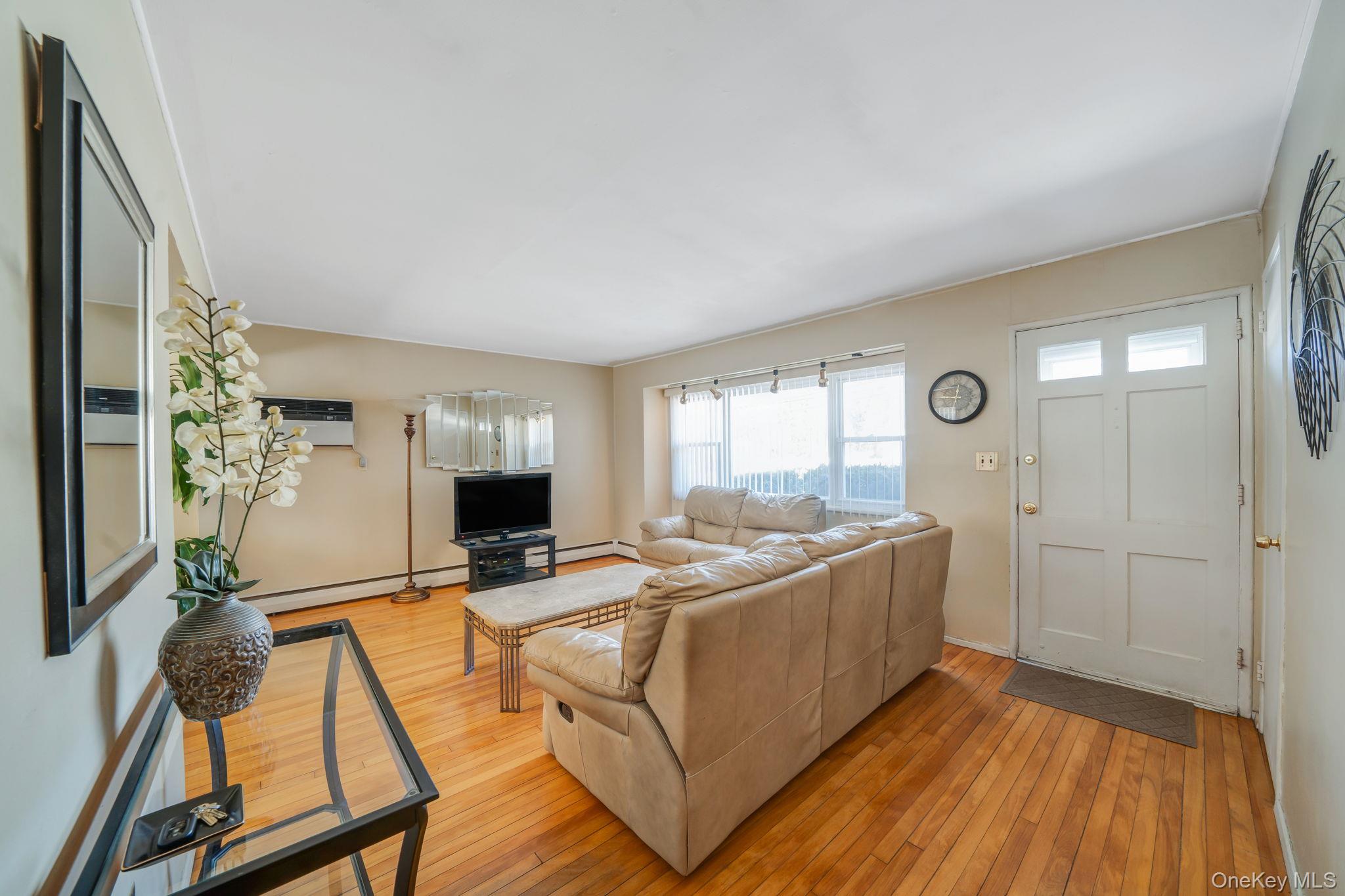24 Kings Park Road Commack, NY 11725 - Photo 13 of 32 a living room with furniture a flat screen tv and a wooden floor