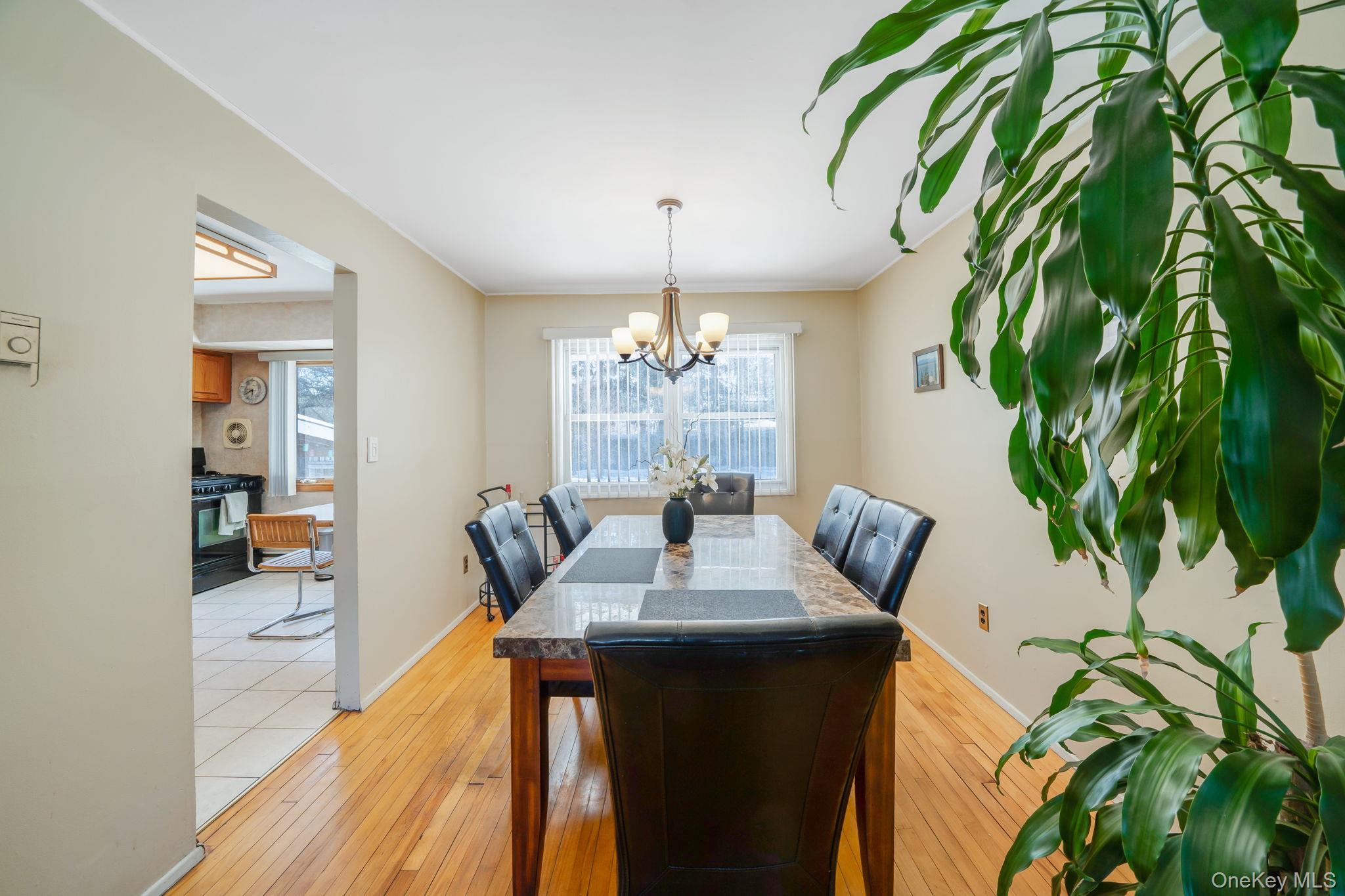 24 Kings Park Road Commack, NY 11725 - Photo 16 of 32 a dining room with chandelier fan and wooden floor