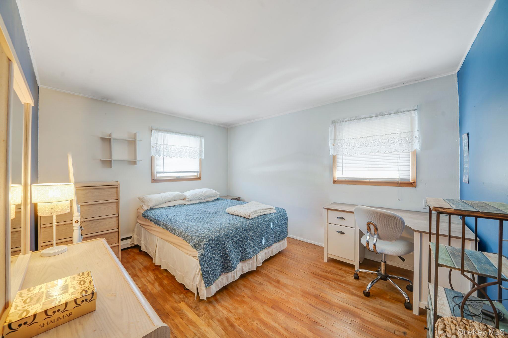 24 Kings Park Road Commack, NY 11725 - Photo 24 of 32 a bedroom with a bed and wooden floor