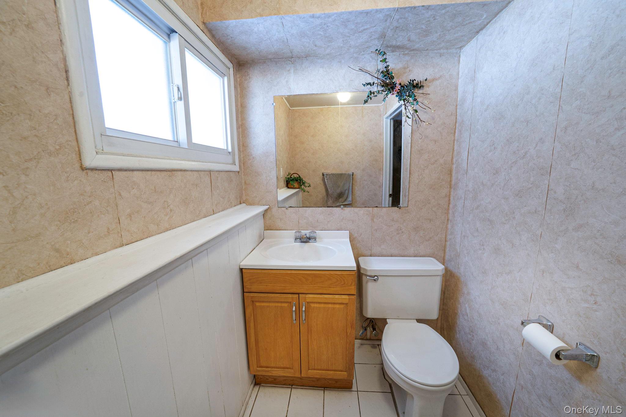24 Kings Park Road Commack, NY 11725 - Photo 28 of 32 a bathroom with a toilet a sink and mirror