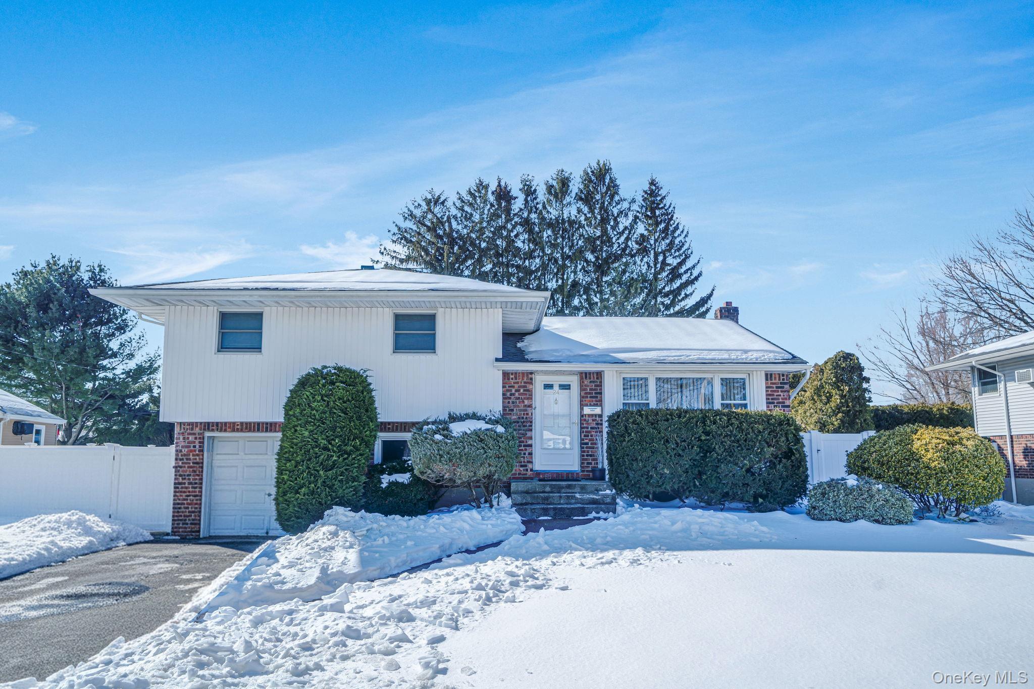 24 Kings Park Road Commack, NY 11725 - Photo 3 of 32 a front view of a house with a yard and garage