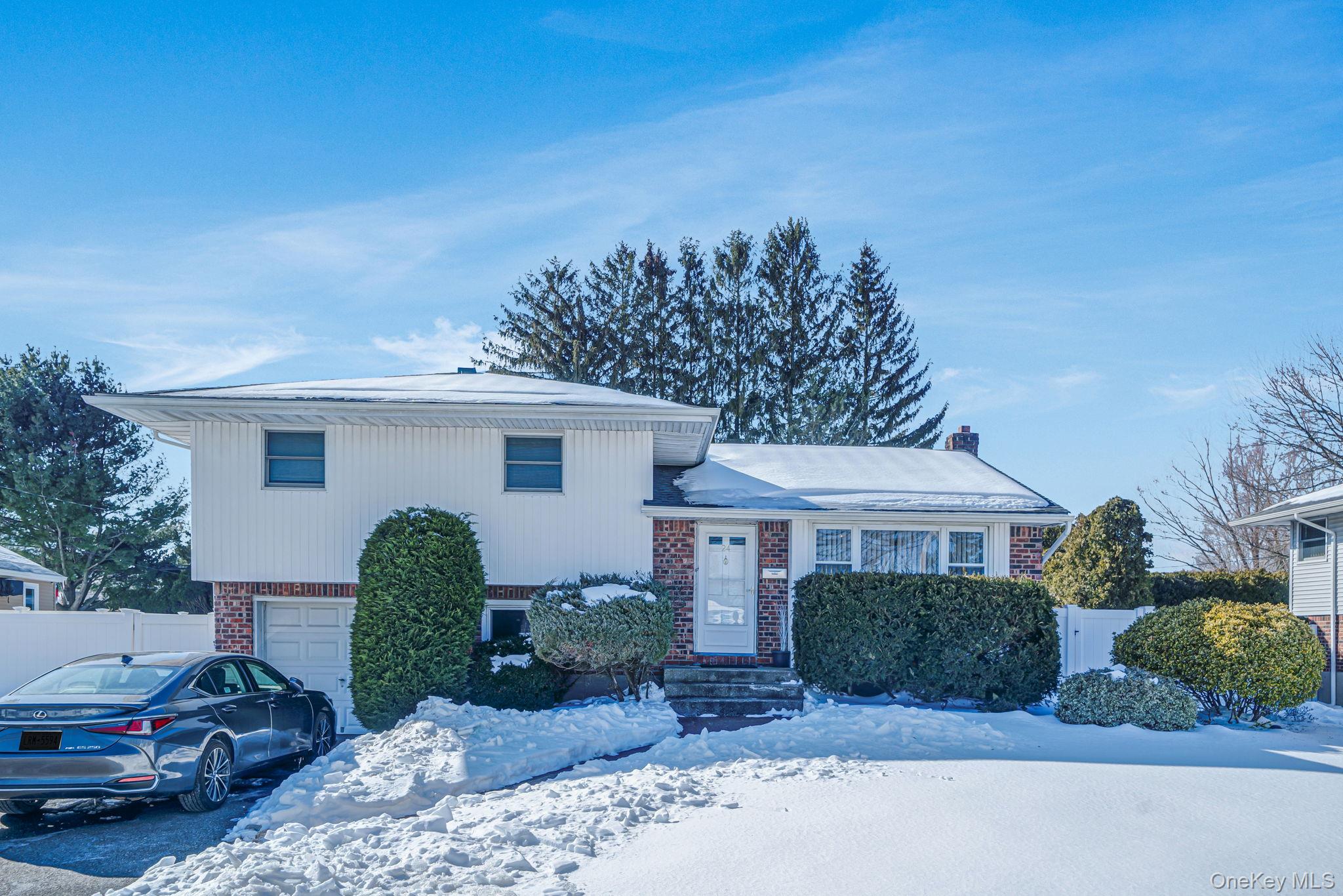 24 Kings Park Road Commack, NY 11725 - Photo 4 of 32 a front view of a house with a yard garage and outdoor seating
