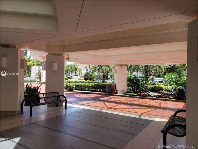 a living room with patio furniture and a large window
