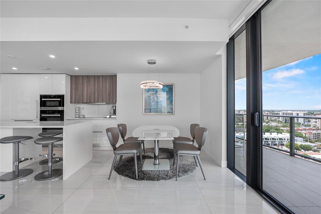 730 North Ocean Boulevard, Unit 1501 Pompano Beach, FL 33062 - Photo 15 of 56 a dining room with furniture and a floor to ceiling window