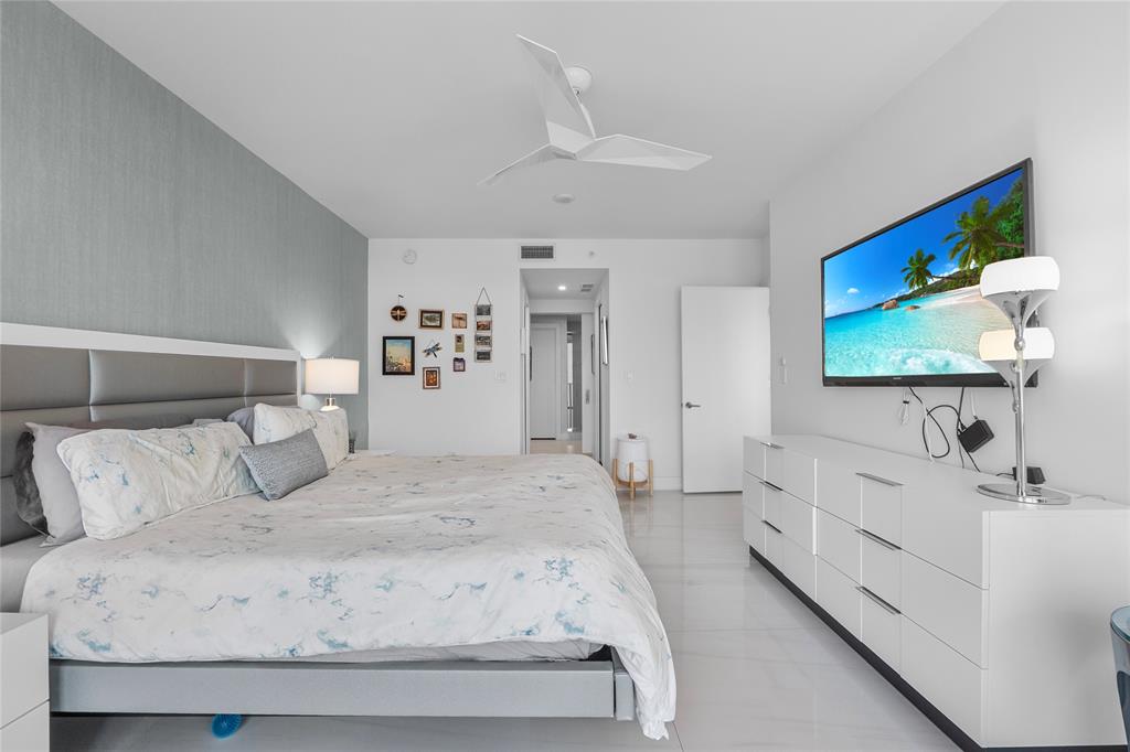 730 North Ocean Boulevard, Unit 1501 Pompano Beach, FL 33062 - Photo 17 of 56 a spacious bedroom with a bed and a flat screen tv