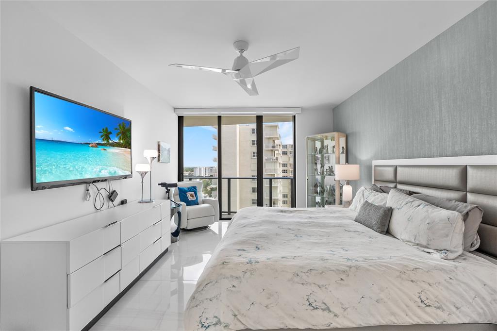 730 North Ocean Boulevard, Unit 1501 Pompano Beach, FL 33062 - Photo 18 of 56 a spacious bedroom with a large bed and a flat tv screen