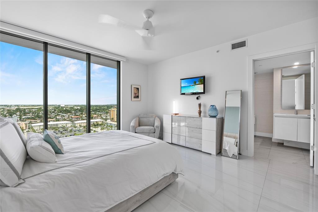 730 North Ocean Boulevard, Unit 1501 Pompano Beach, FL 33062 - Photo 20 of 56 a living room with furniture a large window and a flat screen tv