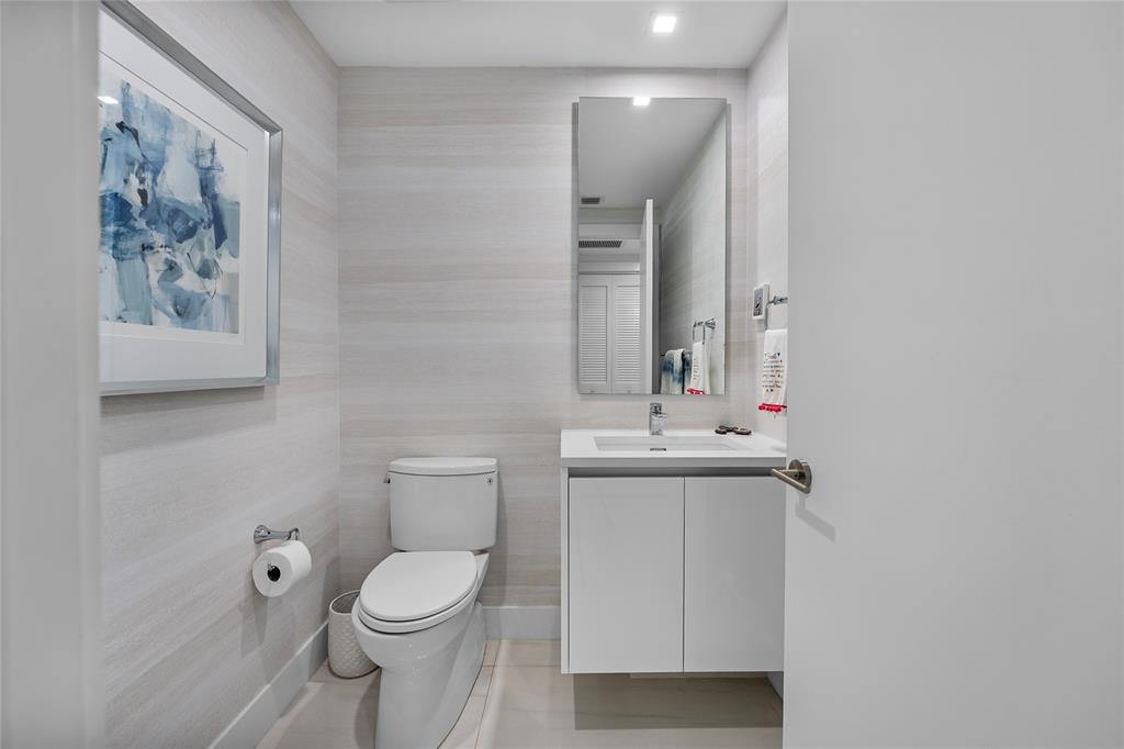 730 North Ocean Boulevard, Unit 1501 Pompano Beach, FL 33062 - Photo 28 of 56 a bathroom with a toilet a sink and mirror